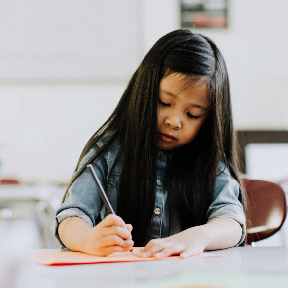 A young girl is writing.